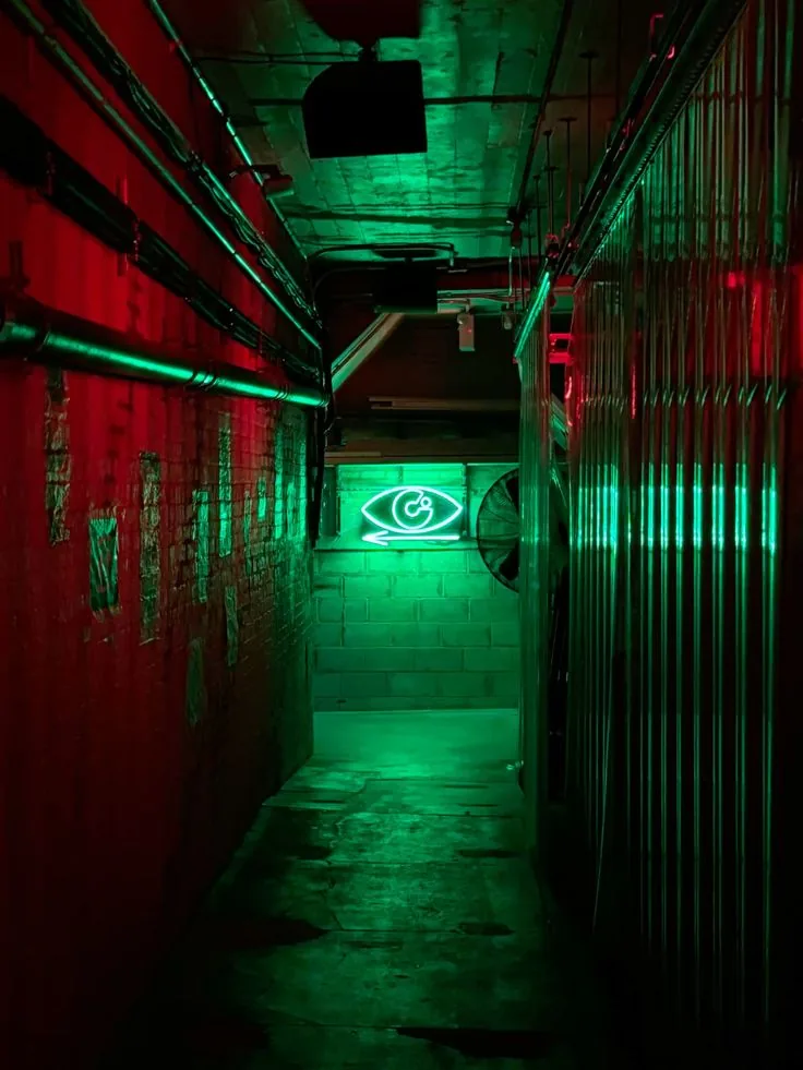Reference photo — green neon service corridor with red brick walls